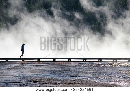 Person Walking In The Clouds In Yellowstone National Park, Wyoming.