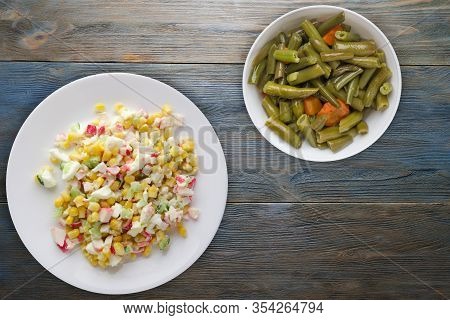 Crab Salad On A White Plate With Vegetarion Salad. Crabs Salad On A Blue Wooden Background Top View
