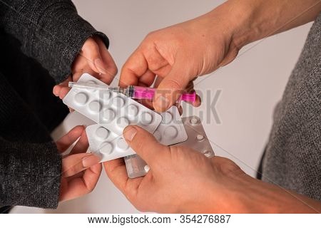 Young People Holding Drugs And Syringe In Their Hands, Close Up Studio Photo