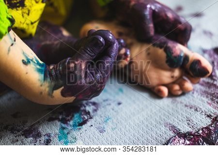 Chlid Playing With Different Color Paintings Ends With Multicolor Hands And Feet
