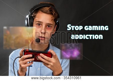 A Tired Teenager With Black Eyes Listlessly Plays A Computer Game With Headphones. Transparent Scree