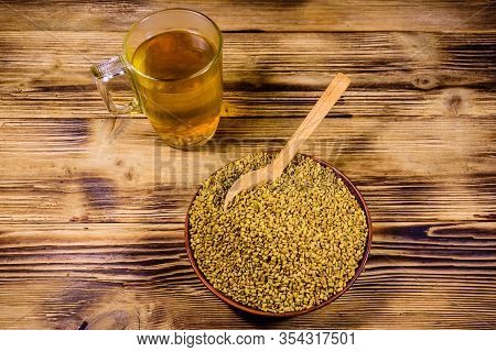 Cup Of Yellow Tea (methi Dana) And Plate With Fenugreek Seeds On Rustic Wooden Table