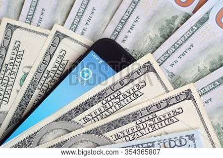 Smartphone Screen With Telegram App And Lot Of Hundred Dollar Bills. Business And Social Networking 