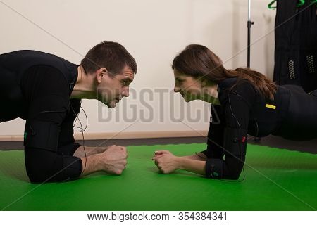 A Young Woman With A Personal Trainer Doing Fitness Exercises In An Ems Suit. Concept: Health, Ems T