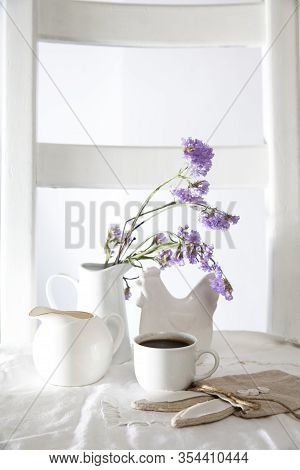 Festive Table Decoration For Easter. Coffee, Milk Jug And A Bouquet Of Blue Flowers In Jug, As Well