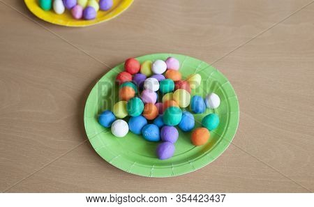 Plastic Plate Full Of Colorful Playdough Balls. Wooden Background