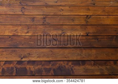 Stained wet deck wooden boards with water drops, brown planks texture
