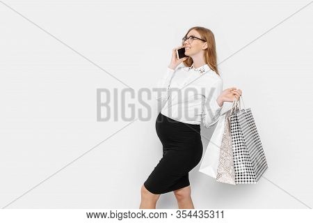 Image Of Young Pregnant Businesswoman Wearing Glasses, Talking On Phone, Holding Bags, Shopping