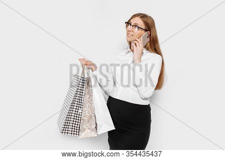 Image Of Young Pregnant Businesswoman Wearing Glasses, Talking On Phone, Holding Bags, Shopping