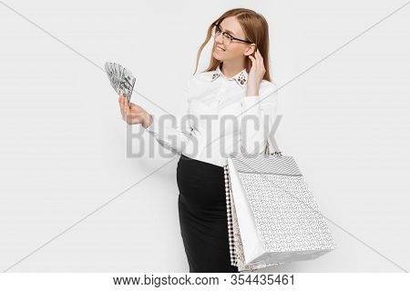 Image Of Young Pregnant Businesswoman In Glasses Posing Holding Banknotes And Bags Shopping