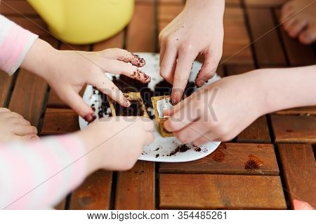 Close-up Of Children's Hands Planting Flowers And Vegetables In Small Biodegradable Seedling Pots. C