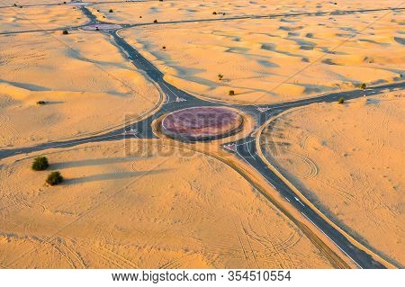Aerial View Of Circle Roundabout, Half Desert Road Or Street With Sand Dune In Dubai City, United Ar