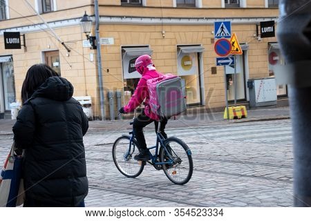 Helsinki, Finland - 3 March 2020: Foodora Delivery Man On Bike On Street With Taco Bell, Illustrativ