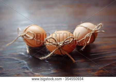 Easter Beige Eggs Decorate With Rope On Brown Wooden Background