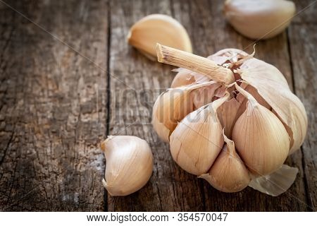 Dried Garlic With Garlic Cloves On Old Wooden Table.