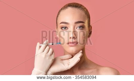Model Girl Receiving Injection During Lips Plumping Botox Procedure Looking At Camera Posing Over Pi