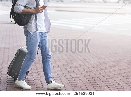Changing Terminals. Unrecognizable Man Walking In Airport Exteriour With Luggage, Passport And Bordi