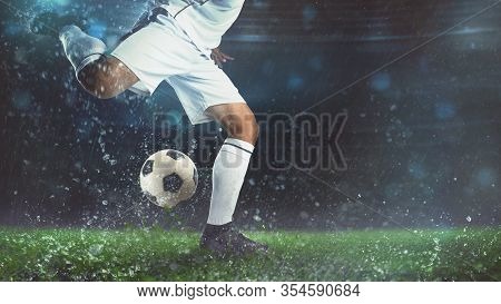 Close Up Of A Soccer Scene At Night Match With Player In A White Uniform Kicking The Ball With Power