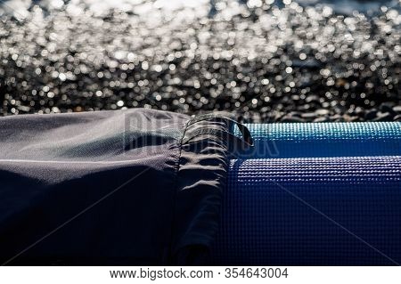 Rolled-up Yoga Mats In A Gym Bag. Exercise In The Fresh Air, On The Beach Or Ocean. Sports Mats On T