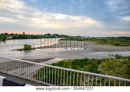 Passing Over The Bridge Over The River. The Landscape Of The River, The Surface And The Trees Of The
