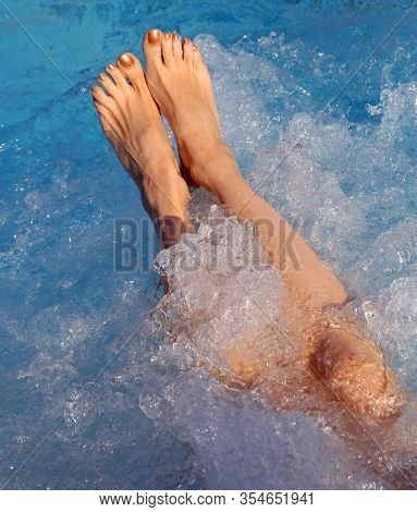 Feet Of Young Woman During The Whirlpool Therapy In The Spa Pool