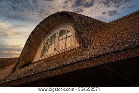 Nice Thatched Roof And Vindow In Sunset With A Beautiful Sky