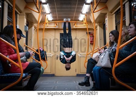 04 Of March 2020, Kiev, Ukraine, Subway Carrage On The Syrets Station. Girl Hanging By Feet Upside D