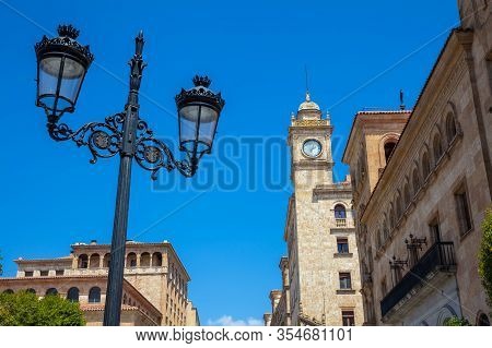 Beautiful Street Lamp And The Clock Tower Of An Antique Building At Zamora Street In Salamanca City
