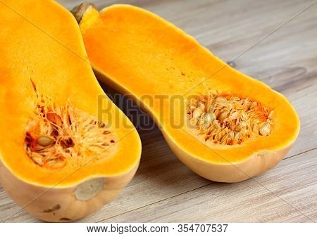 Pumpkin Butternut Liscia Cut In Half.   Yellow Delicious Pumpkin On Wooden Table.