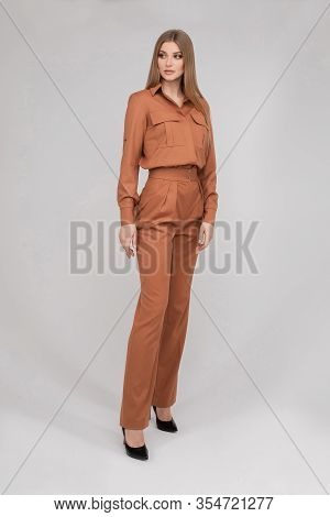 Attractive Young Blonde Model With Perfect Slim Body Posing In Trendy Orange Pantsuit Full Length