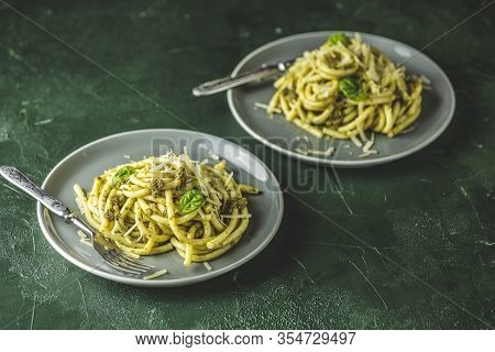 Two Gray Dishes Of Spaghetti Pasta Bucatini With Pesto Sauce And Parmesan. Italian Traditional Perci