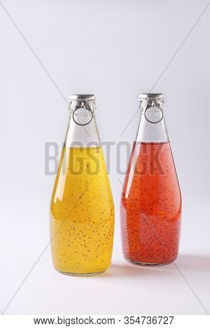 Yellow And Red Drinks With Basil Seeds Or Falooda Seeds Or Tukmaria In Bottles On White Background, 