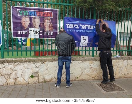 Holon, Israel. March 2, 2020. Political Campaigners Placing A Poster Calling To Vote For The Yisrael