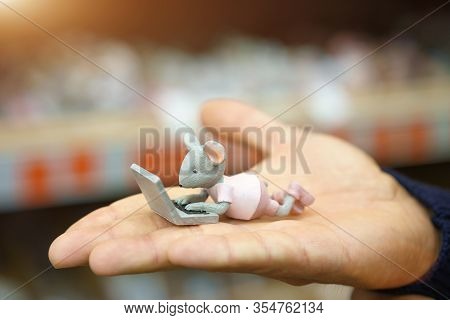 On The Hand Is A Small Figure Of A Mouse.