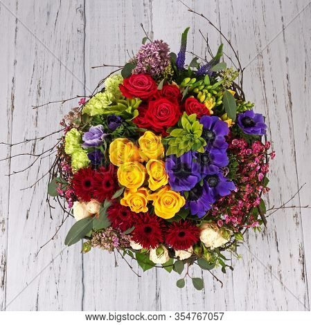 Flower Arrangement With Roses, Lilac And Anemones On Light Wooden Floor