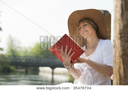Frau entspannen beim Lesen eines Buches von Fluss
