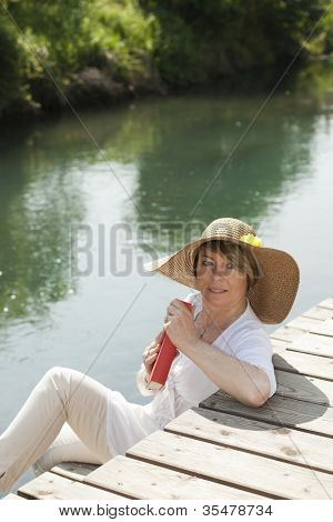 Frau sehr beim Lesen eines Buches von Fluss