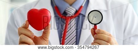 Male Medicine Doctor Holding Red Heart And Stethoscope Head In Front Of Chest Closeup. Medical Help 