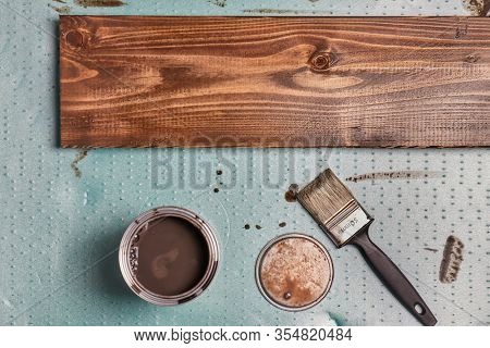 Painting lumber with wood stain coloring with paint brush