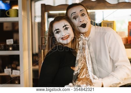 Happy Man Mime Giving A Chocolate Eiffel Tower To His Girlfriend. Two Happy Mimes On A Date In The C