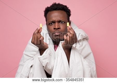 African American Youngman Inserting Ear Plugs Happy With Solution Of Neighbours