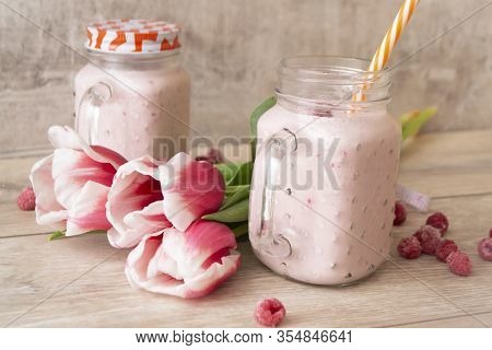 Berry Mix Protein Smoothies In Mason Jar On Light Background With Tulips Flowers, Spring Healthy Lif