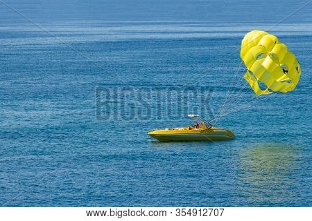 Preparing Tourists To Fly On The Yellow Wing For Parasailing.