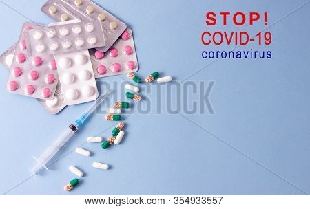 Coronavirus Phrase Text On A Blue Background With Medicines And A Syringe. The Concept Of The New 20