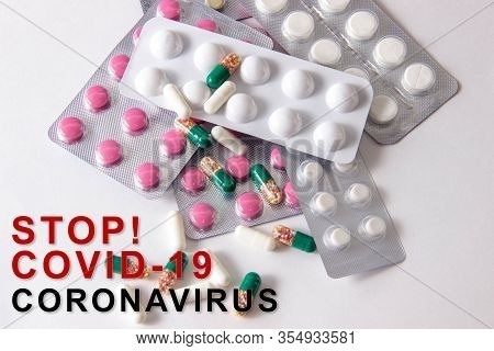Coronavirus Phrase Text On A White Background With Medicines And Pills. The Concept Of The New 2019 