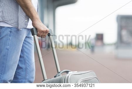 Waiting For Cab. Unrecognizable Man Standing Outside Of Airport And Carrying Luggage, Cropped Image 