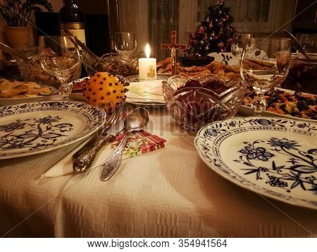 Lithuanian Christmas Eve Table With Christmas Wafers, Candle And Various Dishes