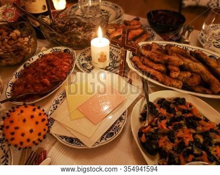 Lithuanian Christmas Eve Table With Christmas Wafers, Candle And Various Dishes