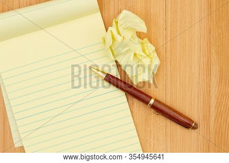 Yellow Legal Notepad Paper With Crumpled Paper And Pen On Wood Desk With Copy Space For Your Busines