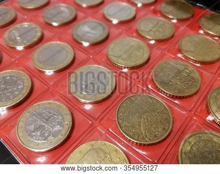 Various coins in the numismatics album close up. Hobby of numismatics